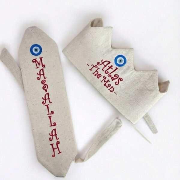 Kırmızı nakış detaylı ve nazar boncuğu işlemeli, ekru zeminli sünnet tacı ve maşallah kemer seti.