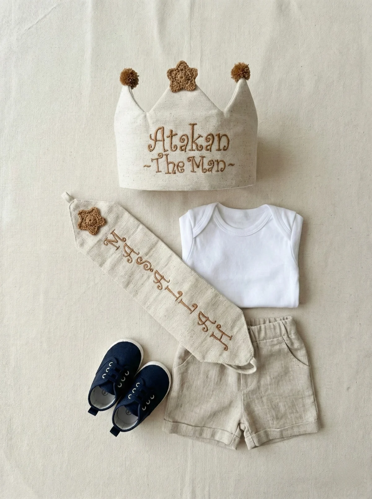 Üzerinde kahverengi yıldız ve ponpon bulunan, keten kumaşlı el yapımı sünnet tacı.